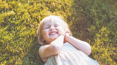 happy girls laying on green grass