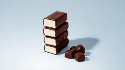 Chocolate-coated ice cream bars with caramel filling stacked vertically