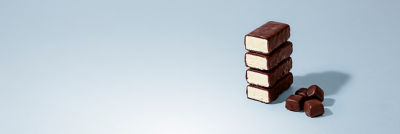 Chocolate-coated ice cream bars with caramel filling stacked vertically
