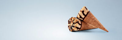 Cono de waffle decorado relleno de helado y con cobertura de chocolate