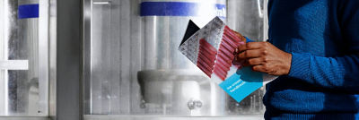 Person holding ice cream carton package in industrial setting
