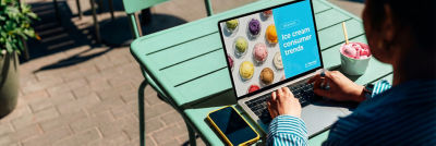 Person using digital screen to select ice cream products outdoors