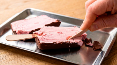 Person serving frozen dessert product on tray