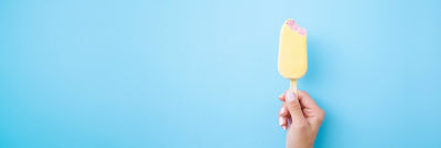 Mano que sostiene un palito de helado