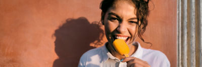 Woman eating ice cream outdoors in sunny lifestyle setting