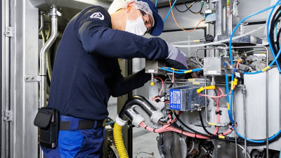 overall technician performing machine maintenanc