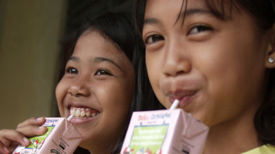 Girls drinking milk from a portion size carton