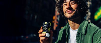 Man drinking coffee on-the-go, coffee drink in Tetra Pak carton package