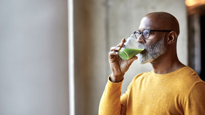 man drinking a green smoothie