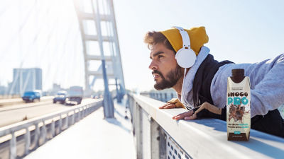 Man exercising on bridge, protein drink in Tetra Prisma Aseptic carton