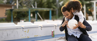 Young man playing with little girl, juice in Tetra Prisma Aseptic carton 