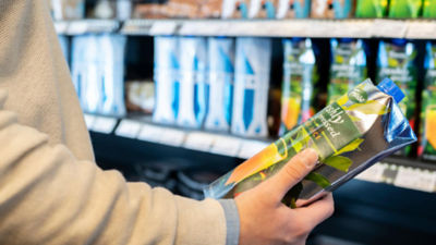 Man holding carton in supermarket