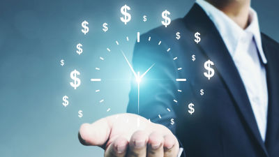 Man holding out his hand with digital clock and dollar signs coming up from the hand