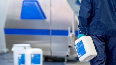 Hombre con un recipiente de lubricante, consumibles Tetra Pak 