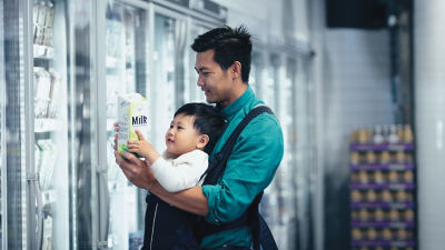 Man with a baby, shopping milk