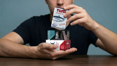 Man holding two Tetra Recart carton packages with tuna
