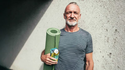 Man with yoga mat and coconut water