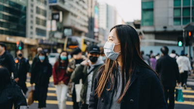 Des piétons dans un espace bondé portant des masques