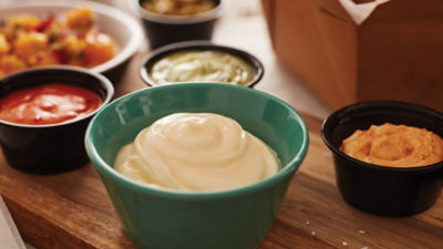 Four wooden spoons with sauces
