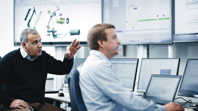 Uomini che analizzano dati davanti a schermi di computer