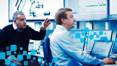 Men looking at screens, blue pixels around them 
