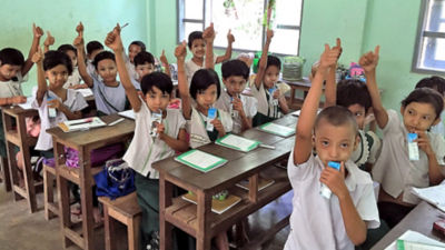 Myanmar children in classroom drinking milk