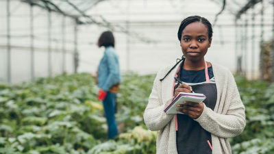 Une femme prenant des notes dans une serre