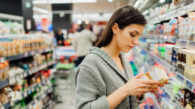 Consumidora conferindo o rótulo da embalagem no supermercado