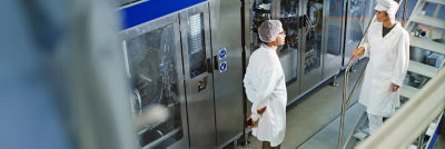 Operadores en un sitio de producción, máquina de llenado