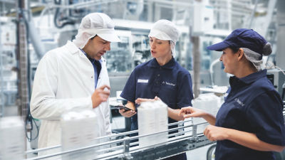 Three workers talking together in a lab