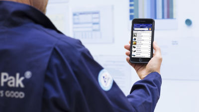 Tetra Pak service engineer with smartphone, spart parts online catalogue
