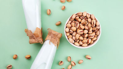 Pistaches et boissons sur fond vert