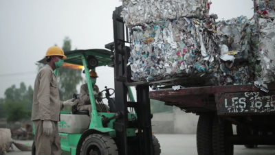 Homem trabalhando na reciclagem de embalagens cartonadas da Tetra Pak enquanto opera uma empilhadeira