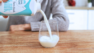 Latte versato in un bicchiere, confezione in cartone Tetra Top