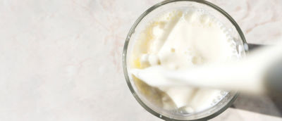 Milk pouring into glass from above