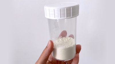 Hand holding powder mixture in a container