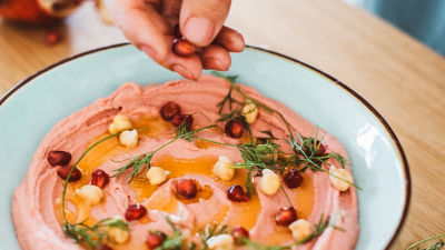 Close-up of hummus with chickpeas and herbs 