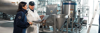 Workers inspecting industrial processing tank
