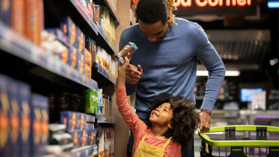father and daughter walking in supermarket