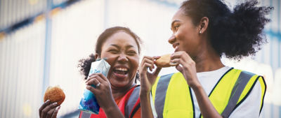 two women laughing drinking from carton