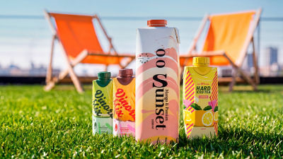 RTD alcoholic beverages in carton on the grass with beach chairs in the background
