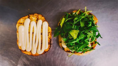 Two slices of bread with mayonnaise and salad on them