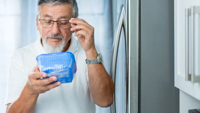 senior man checking expiry date on food 