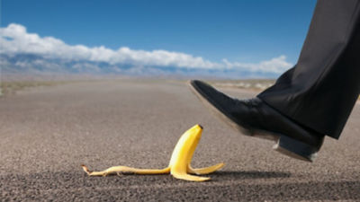 A shoe stepping on a banana peel on the road