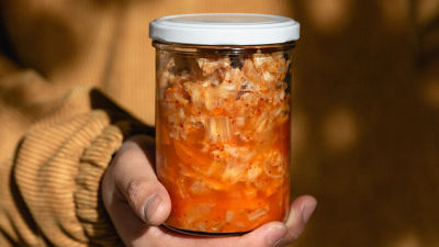 Una persona sosteniendo un vaso con comida fermentada
