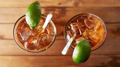 Two soft drinks with ice and lime on a table