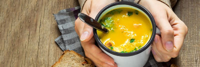 Hands holding cup with soup