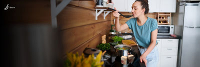 Mulher cozinhando em uma cozinha e experimentando sopa