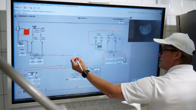 Man looking at process flow on big screen