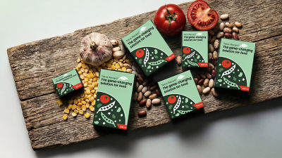 Tetra Recart carton packages, corn, beans and fresh tomatoes on wooden cutting board